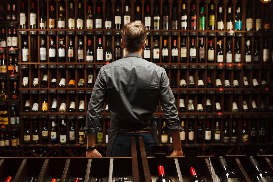 A man looking over an amazing selection of wine bottles!
