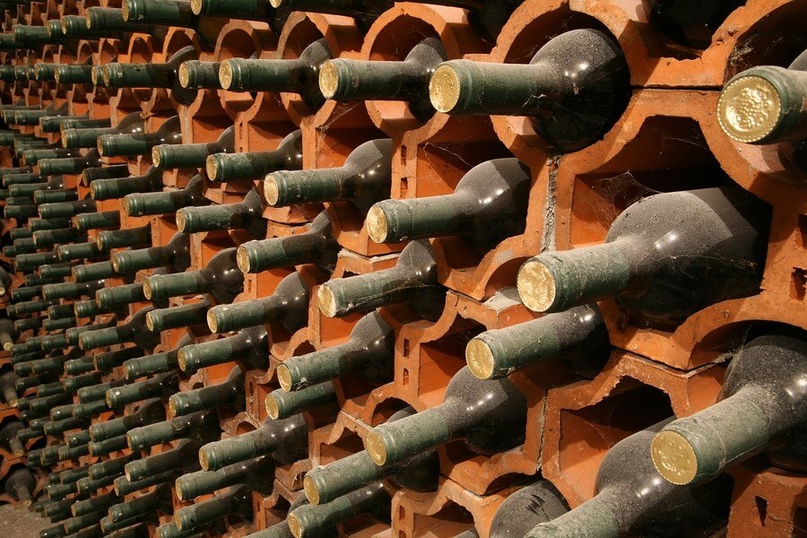 A wall of dusty wine bottles, displaying how to properly store wine!
